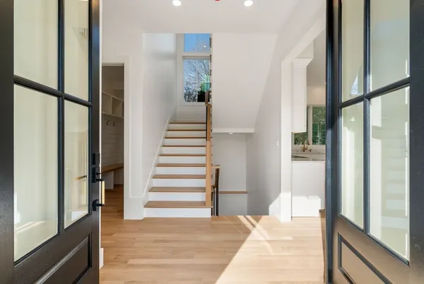 a view of a bedroom with wooden floor and windows