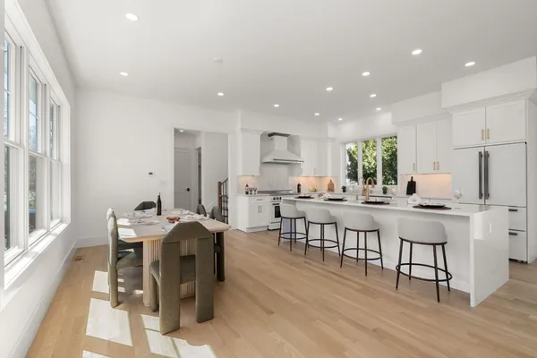 a kitchen with stainless steel appliances kitchen island granite countertop a dining table chairs and view living room
