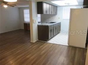 a kitchen with stainless steel appliances a stove a refrigerator a sink a refrigerator white cabinets and wooden floor