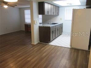 8928 Sterling Lane Port Richey, FL 34668 - Photo 5 of 6 a kitchen with stainless steel appliances a stove a refrigerator a sink a refrigerator white cabinets and wooden floor