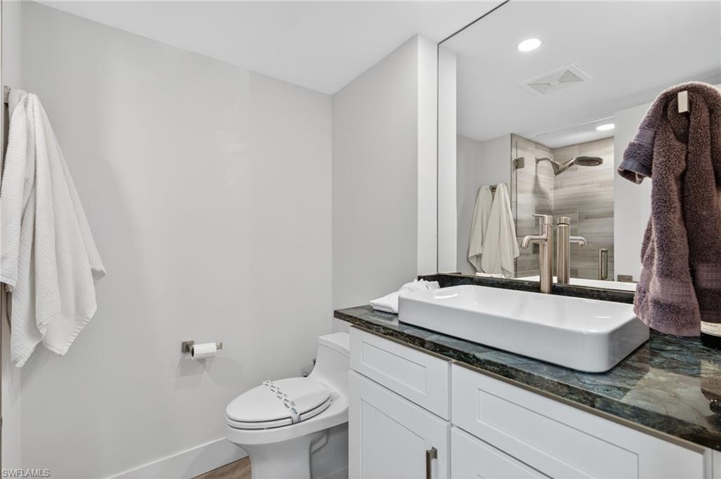 1215 Edington Place, Unit A2 Marco Island, FL 34145 - Photo 16 of 29 a spacious bathroom with a granite countertop sink a toilet a mirror and shower