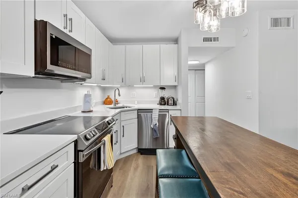 a kitchen with stainless steel appliances granite countertop a sink stove and microwave