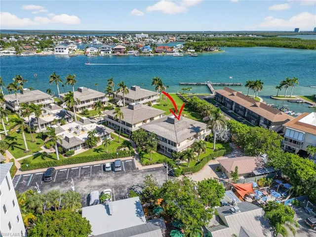 an aerial view of ocean and residential houses with outdoor space