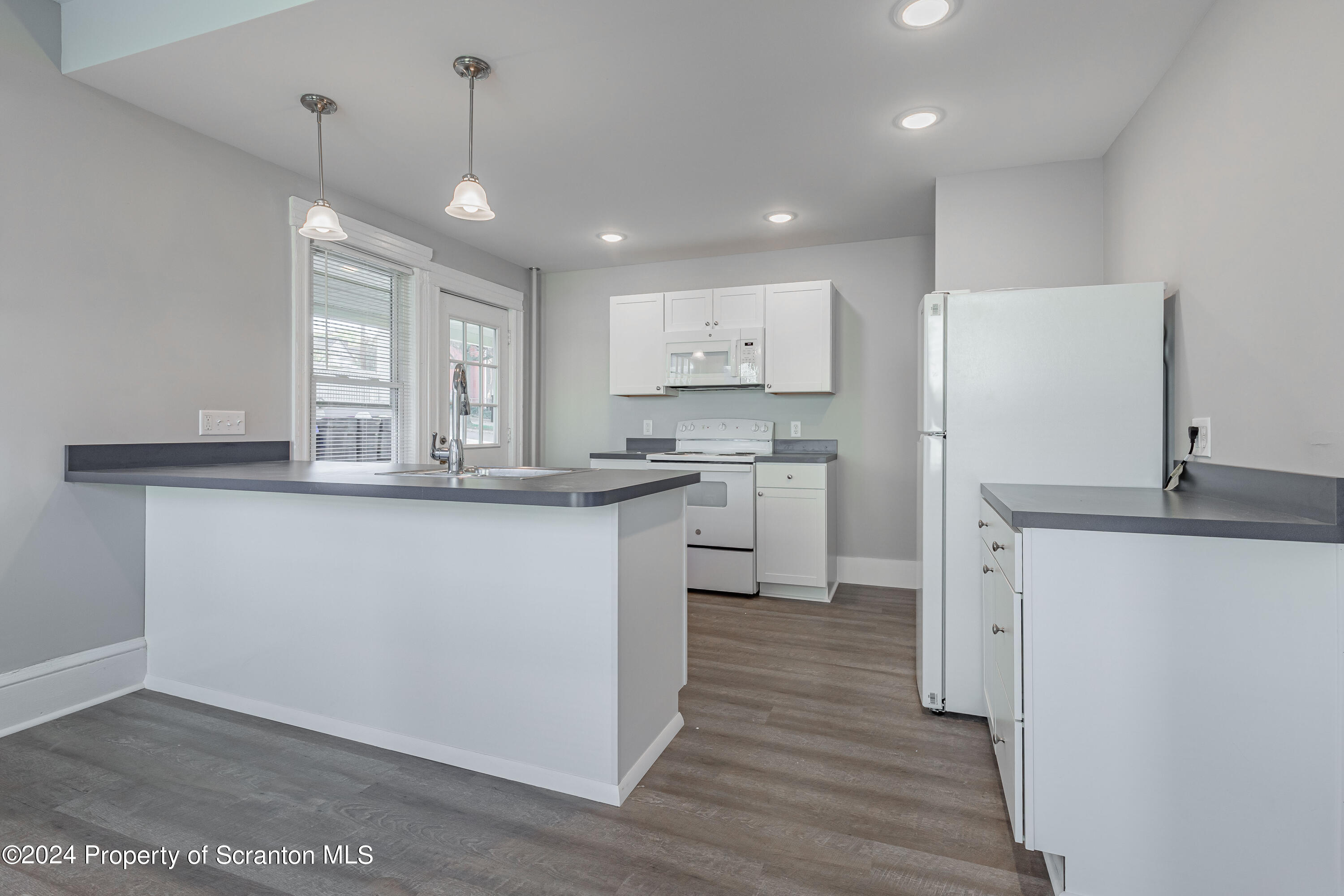 800 Quincy Avenue Scranton, PA 18510 - Photo 3 of 23 a kitchen with stainless steel appliances granite countertop a sink a stove a refrigerator and island with wooden floor