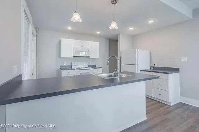 a kitchen with kitchen island a sink appliances and a counter top space