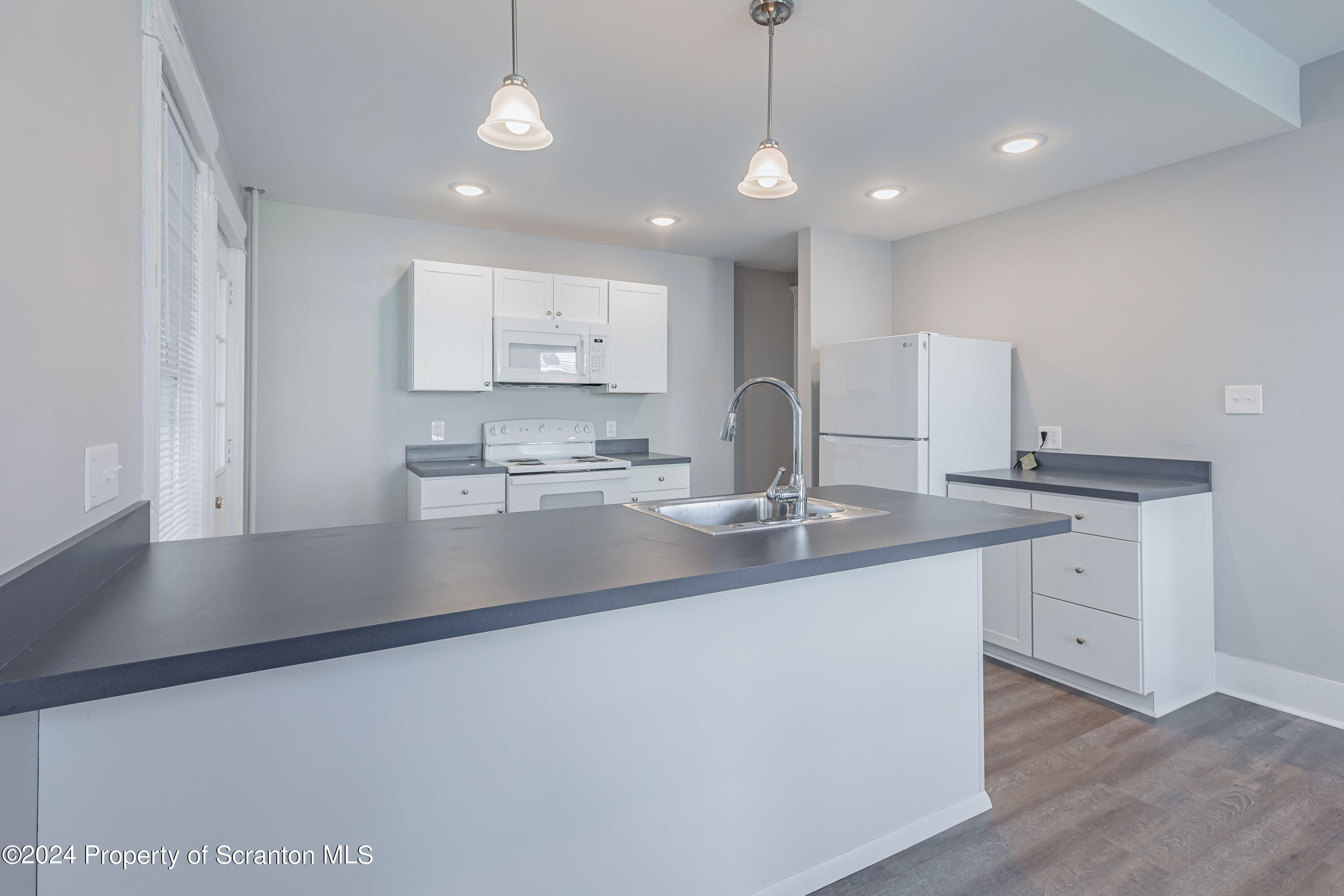 800 Quincy Avenue Scranton, PA 18510 - Photo 8 of 23 a kitchen with kitchen island a sink appliances and a counter top space