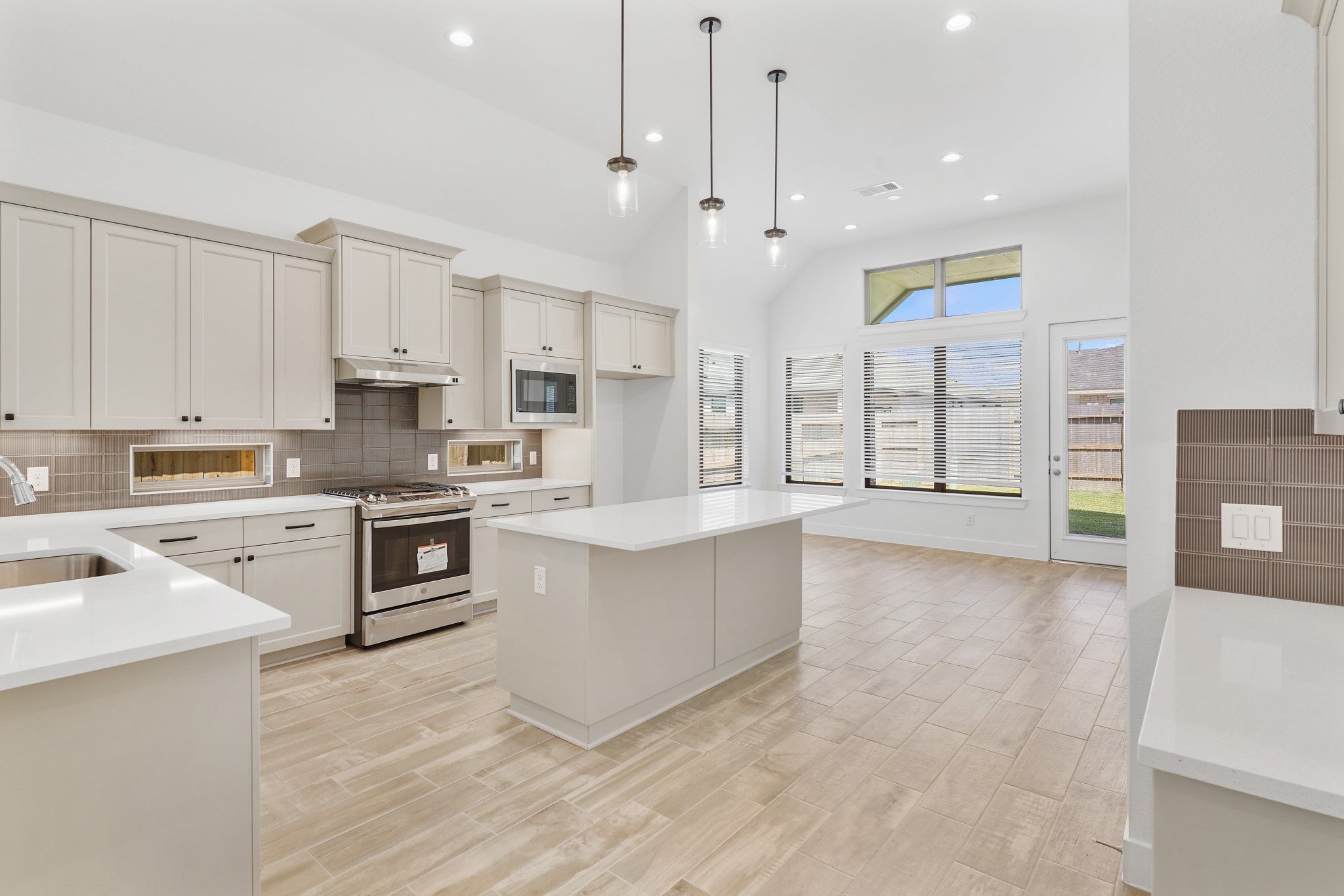 515 Tawny Rim Drive Willis, TX 77318 - Photo 2 of 22 a large kitchen with stainless steel appliances kitchen island granite countertop a stove a sink a refrigerator and white cabinets