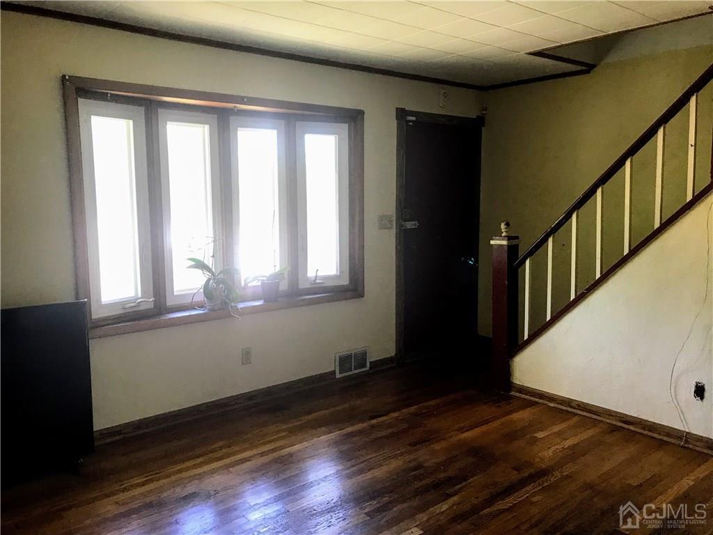 1606 Oak Tree Road Iselin, NJ 08830 - Photo 4 of 9 a view of an empty room with wooden floor and a window