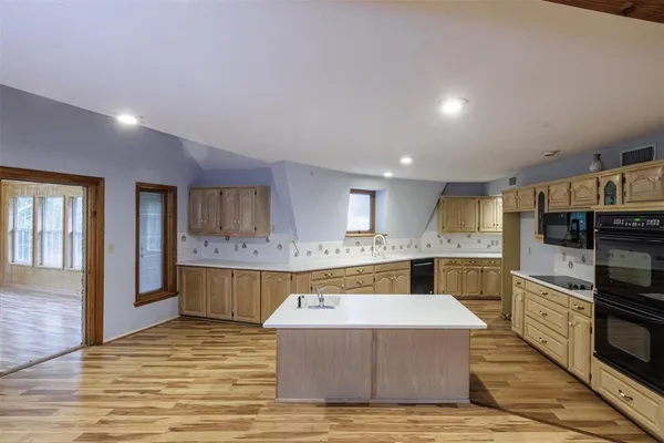 a kitchen with stainless steel appliances kitchen island granite countertop a sink and cabinets