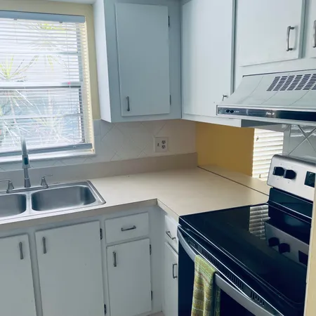 a bathroom with a granite countertop toilet sink and mirror