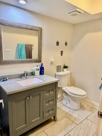 a bathroom with a granite countertop toilet sink and mirror