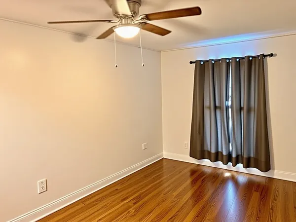 a view of a room with wooden floor and fan