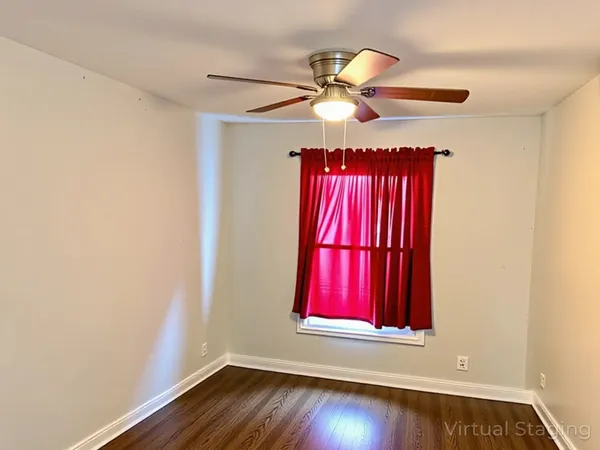 a view of a bedroom with wooden floor and fan