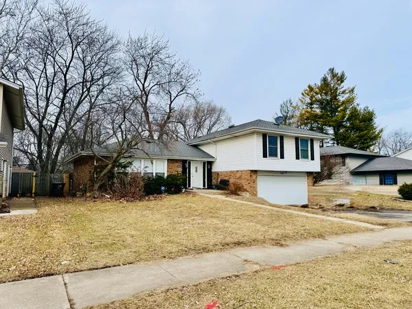 a front view of a house with a garden and yard