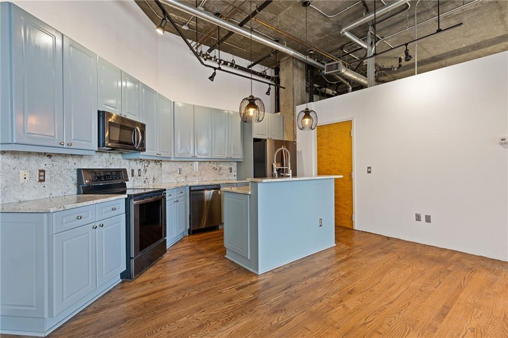 3235 Roswell Road, Unit 818 Atlanta, GA 30305 - Photo 12 of 24 a kitchen with cabinets wooden floor and stainless steel appliances