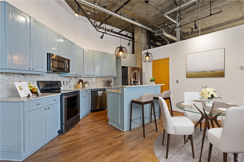 3235 Roswell Road, Unit 818 Atlanta, GA 30305 - Photo 13 of 24 a kitchen with a table chairs microwave and cabinets