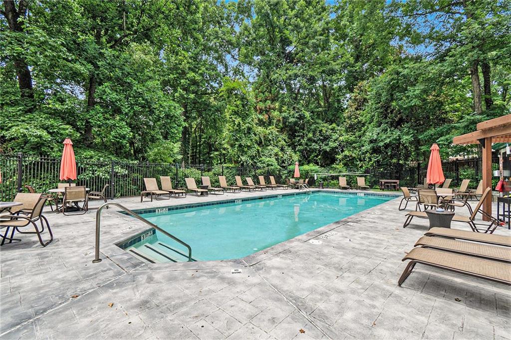 3235 Roswell Road, Unit 818 Atlanta, GA 30305 - Photo 21 of 24 a view of a swimming pool with chairs in a patio