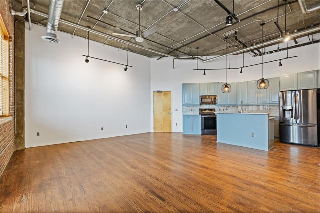 3235 Roswell Road, Unit 818 Atlanta, GA 30305 - Photo 10 of 24 a view of a kitchen with stainless steel appliances wooden floor and a window
