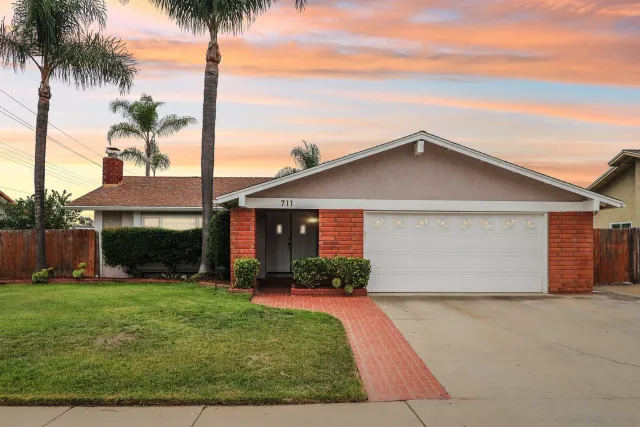 a front view of house with yard and trees