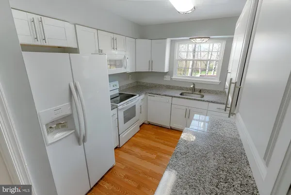 a kitchen with white cabinets and white appliances