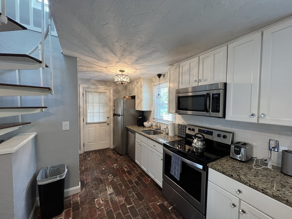 12 State Road, Unit 2E Plymouth, MA 02360 - Photo 2 of 28 a kitchen with stainless steel appliances granite countertop a stove a sink and a microwave