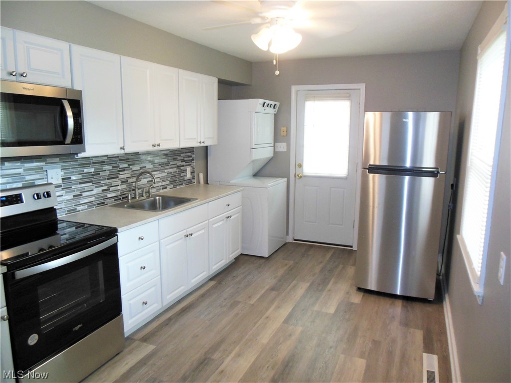 1958 Clyde Road Madison, OH 44057 - Photo 3 of 12 Stove, Refrigerator & Microwave stay, as well as the stackable Washer & Dryer.