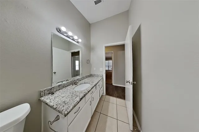 a bathroom with a granite countertop sink and a mirror