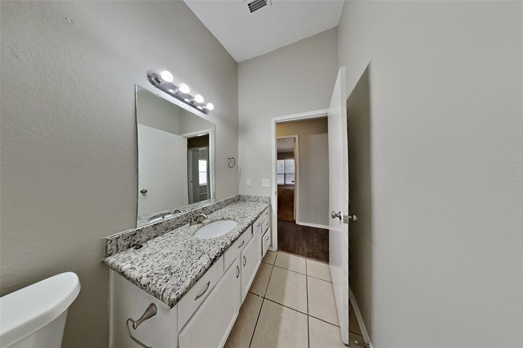4605 Greenfern Lane Fort Worth, TX 76137 - Photo 17 of 18 a bathroom with a granite countertop sink and a mirror