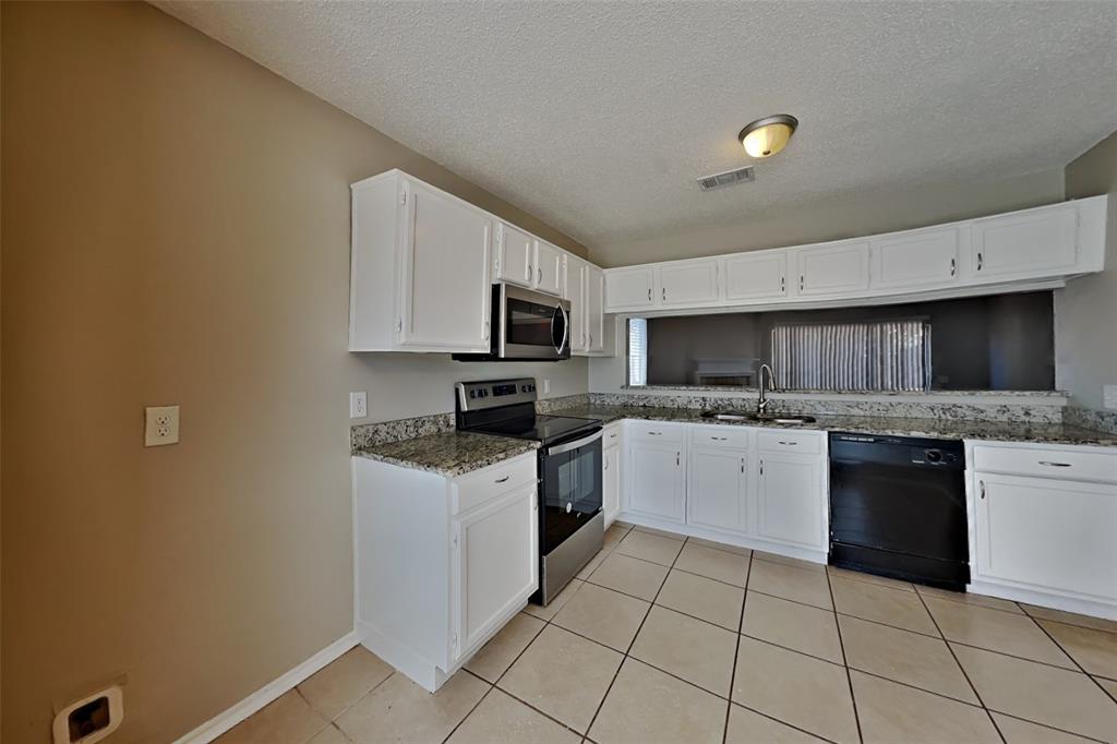 4605 Greenfern Lane Fort Worth, TX 76137 - Photo 4 of 18 a kitchen with a sink a stove top oven and cabinets