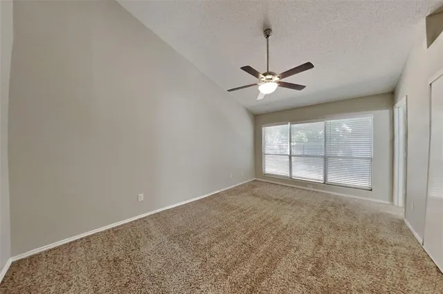 an empty room with fan and windows