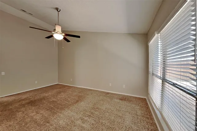 a view of room with a ceiling fan and window
