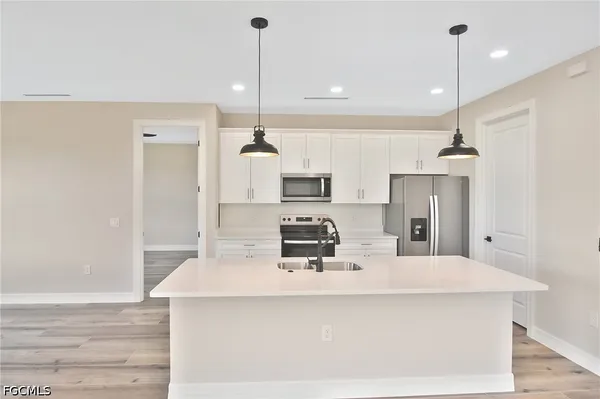 a kitchen with kitchen island a counter top space appliances and cabinets