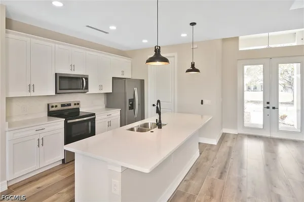 a kitchen with a sink a counter top space stainless steel appliances and a window