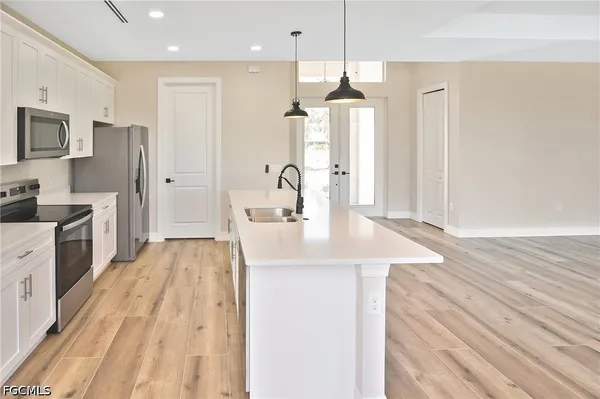 a kitchen with stainless steel appliances kitchen island a refrigerator and a sink