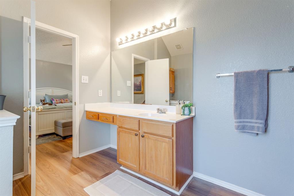 4816 Sleepy Ridge Circle Fort Worth, TX 76133 - Photo 25 of 36 Ensuite bathroom with vanity, light wood finished floors, and a textured wall