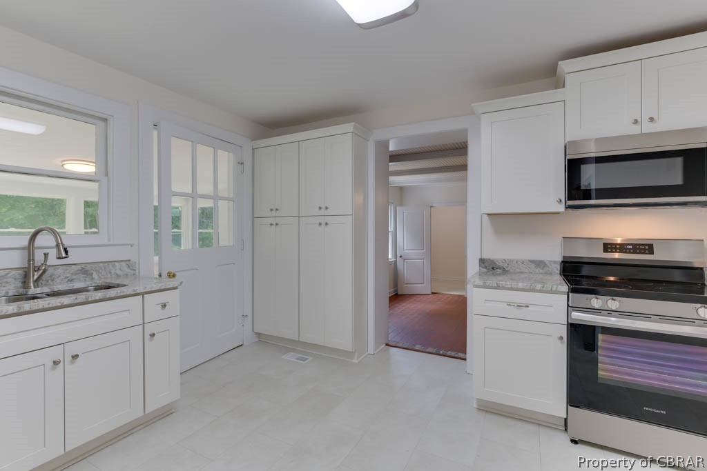 400 Showalter Road Yorktown, VA 23692 - Photo 17 of 49 Kitchen featuring appliances with stainless steel finishes, white cabinets, light tile patterned floors, and sink