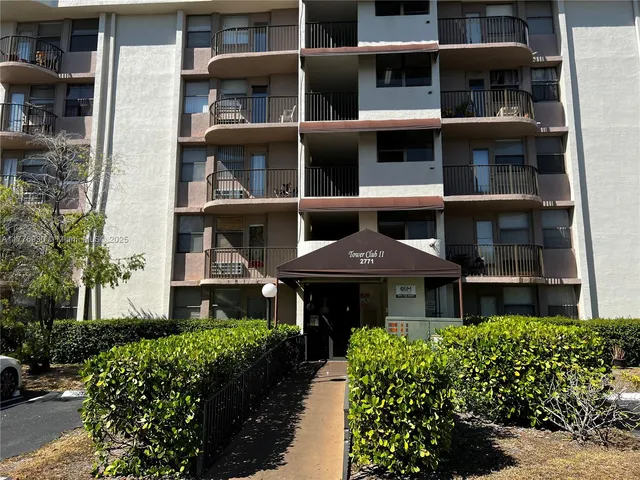 a front view of a building with a garden