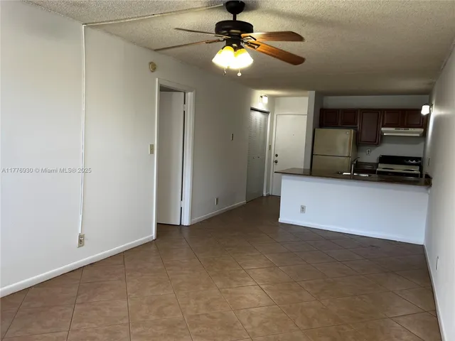 a view of a kitchen with a sink and a chandelier fan