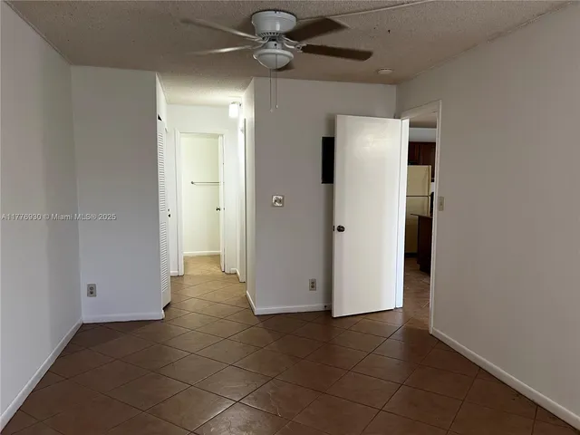 a view of an empty room with a ceiling fan