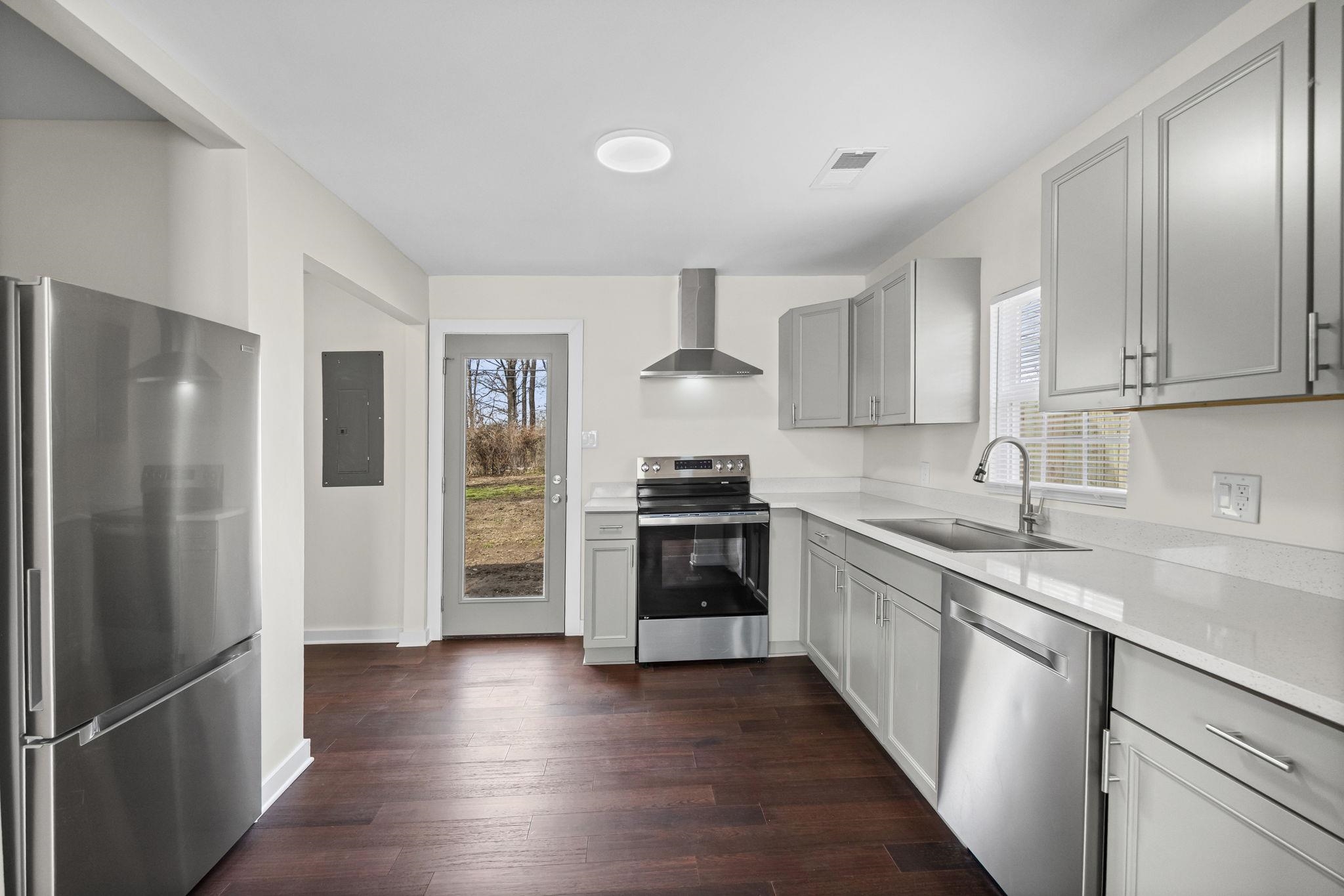 4774 Montgomery Road Millington, TN 38053 - Photo 5 of 20 Kitchen featuring stainless steel appliances, gray cabinets, dark wood-type flooring, electric panel, and light stone countertops