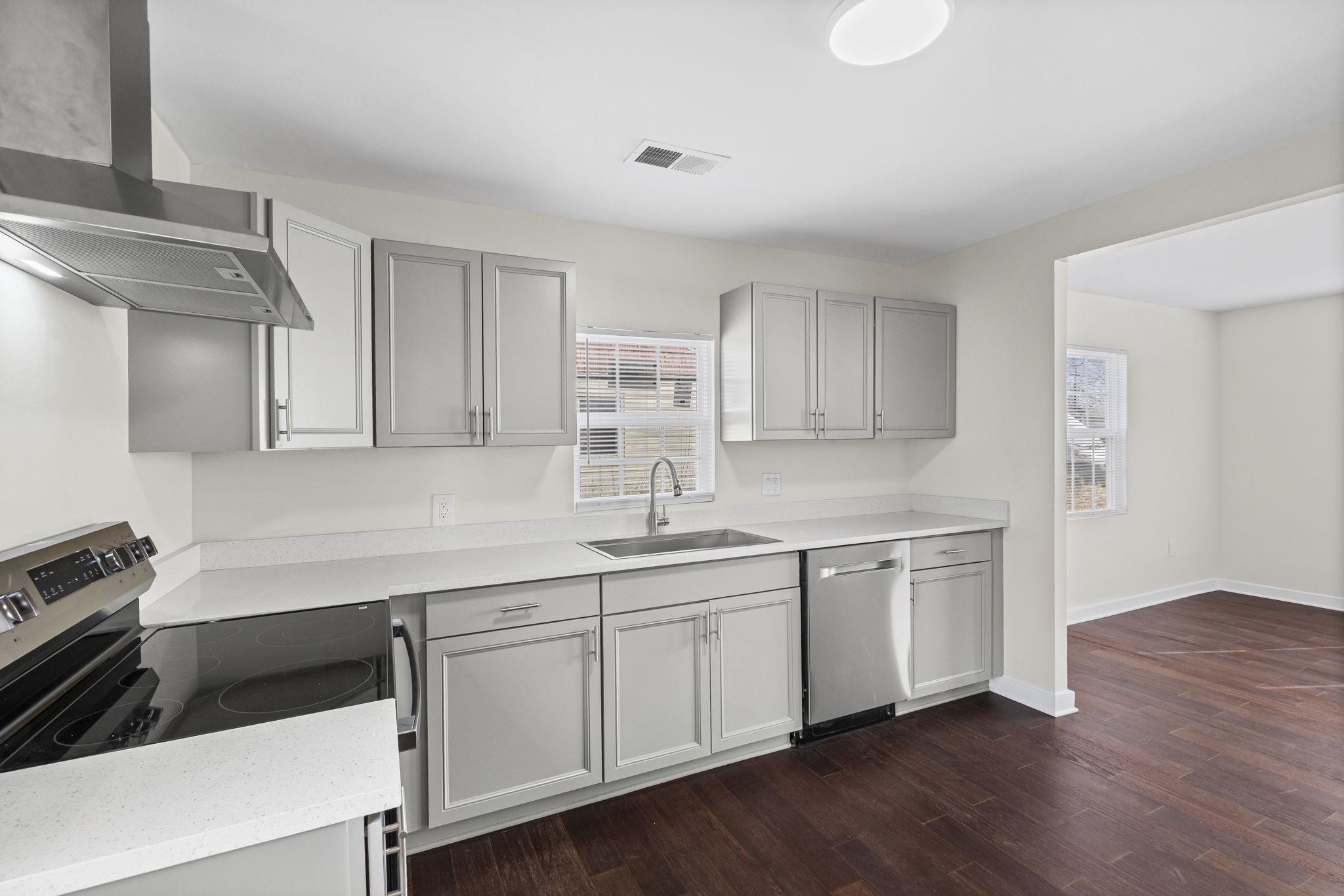 4774 Montgomery Road Millington, TN 38053 - Photo 7 of 20 Kitchen with stainless steel appliances, gray cabinetry, dark wood-type flooring, and light stone counters
