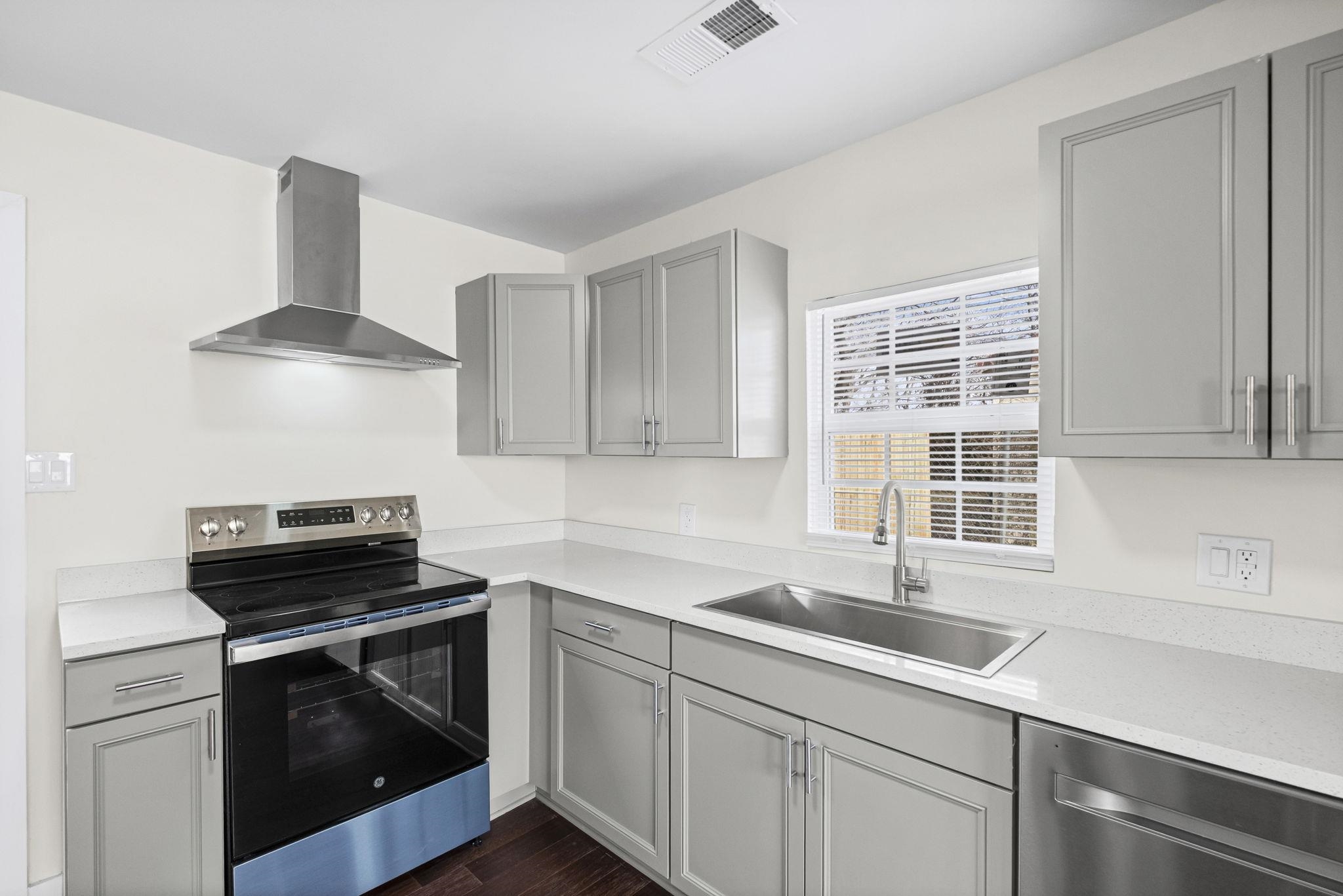 4774 Montgomery Road Millington, TN 38053 - Photo 8 of 20 Kitchen featuring gray cabinetry, stainless steel appliances, dark wood finished floors, and light stone countertops