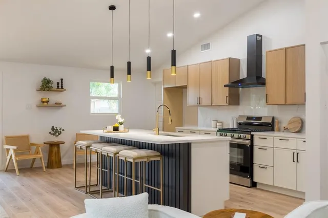 a kitchen with stainless steel appliances granite countertop a sink a stove and a refrigerator