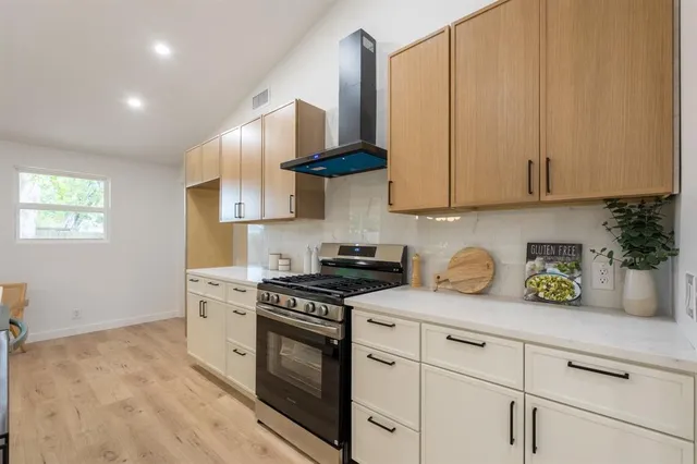 a kitchen with stainless steel appliances granite countertop a sink a stove and a refrigerator