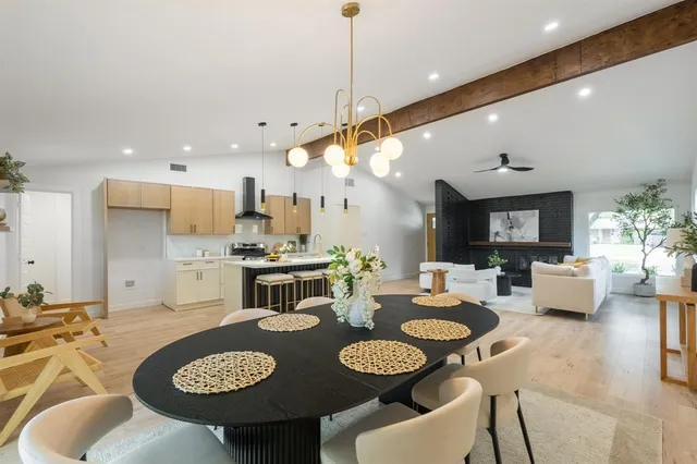 a open dining room with furniture a rug and kitchen view
