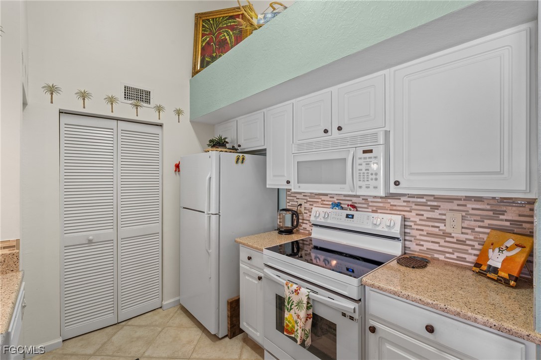 4149 Residence Drive, Unit 824 Fort Myers, FL 33901 - Photo 11 of 25 a kitchen with refrigerator and cabinets