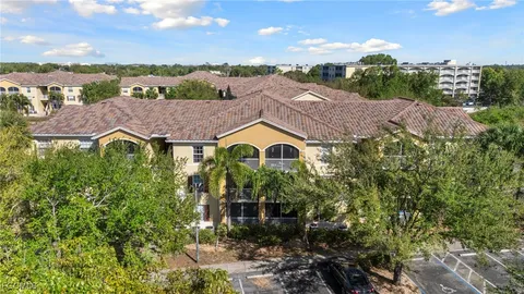 a aerial view of a house with a yard and large tree