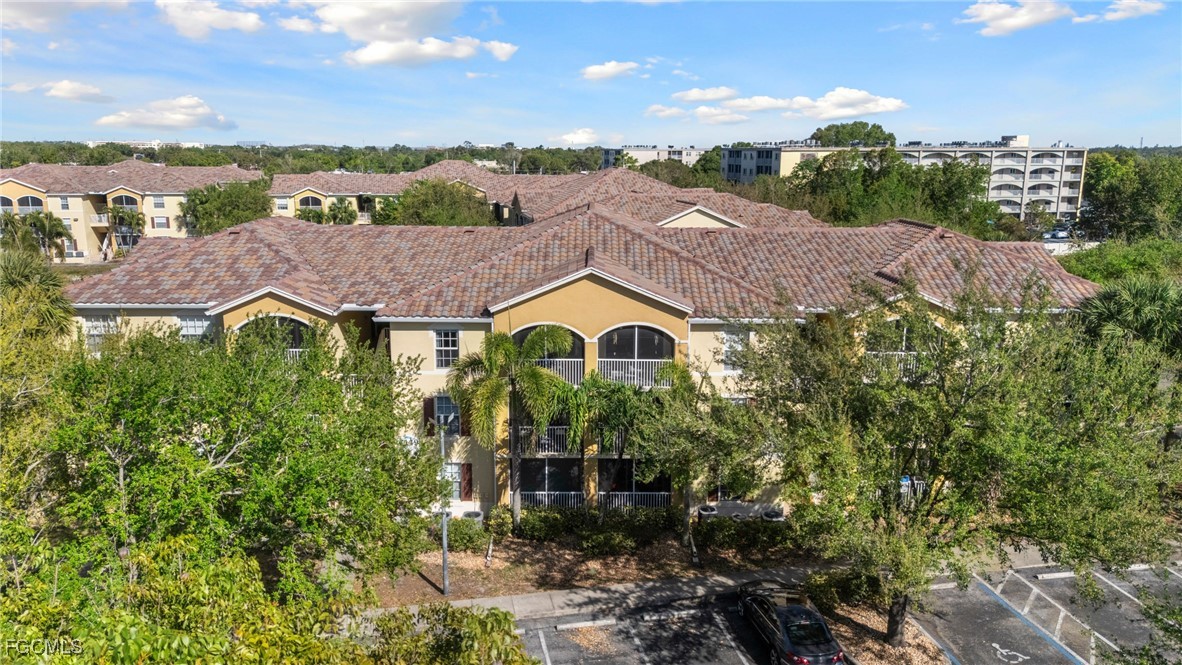 4149 Residence Drive, Unit 824 Fort Myers, FL 33901 - Photo 2 of 25 a aerial view of a house with a yard and large tree