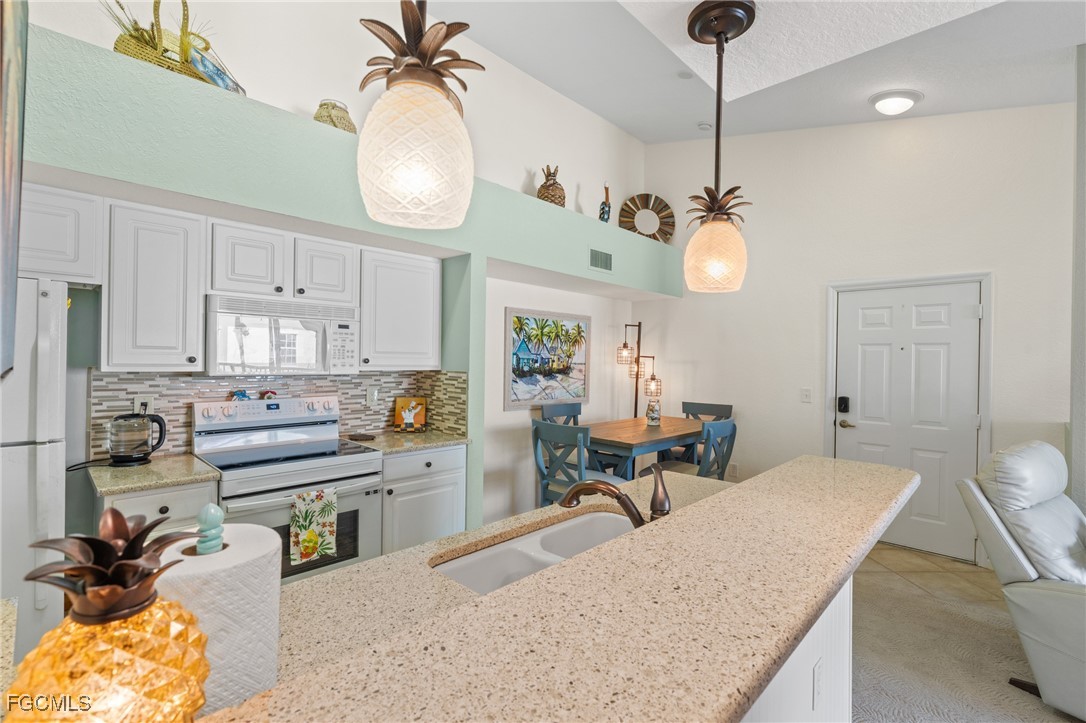 4149 Residence Drive, Unit 824 Fort Myers, FL 33901 - Photo 9 of 25 a very nice looking kitchen with granite countertop a stove a sink a dining table and chairs with wooden floor