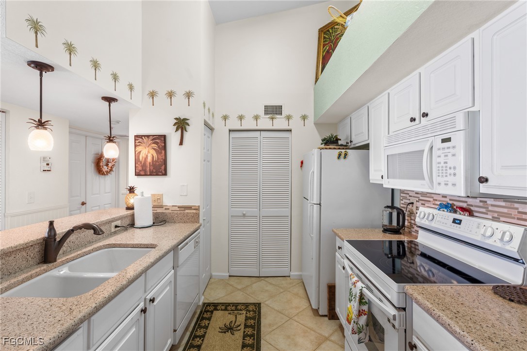 4149 Residence Drive, Unit 824 Fort Myers, FL 33901 - Photo 10 of 25 a kitchen with stainless steel appliances granite countertop a sink stove and refrigerator